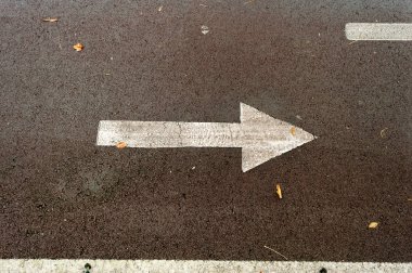 Asfalt yol ile iki yön-e doğru çizilmiş oklar. Karar verme ve seçimler yapma