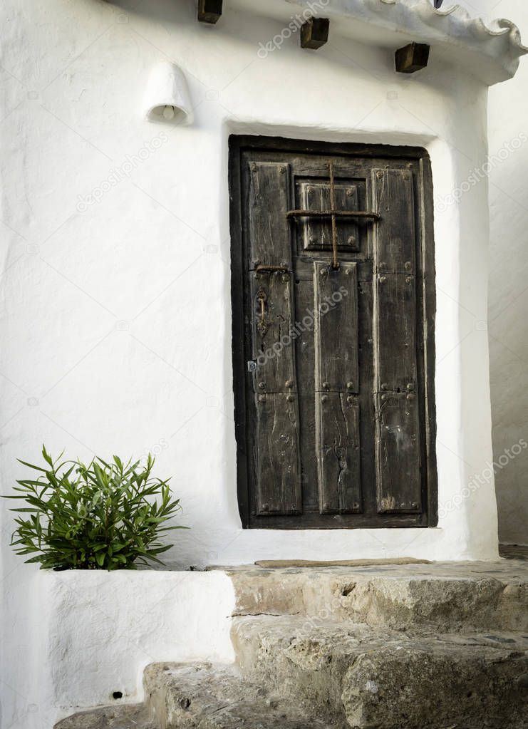 Typical residence with white walls and wood door of the fishing village Binibeca Menorca Spain