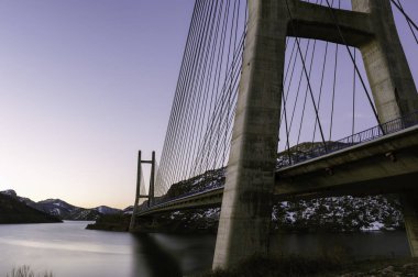 Modern çimento köprü pilon yapısı üzerinde açık mavi gökyüzü.