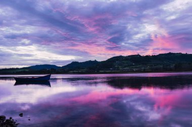 Asturias yataydan, dramatik gökyüzü sırasında gündoğumu günbatımı ile tek tekne Spain.Reflection