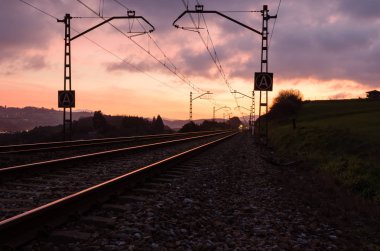 Gün batımında güzel gökyüzü tren istasyonu. Demiryolu, kırmızı bulutlar, Güneş ile renkli mavi gökyüzü, endüstriyel yatay