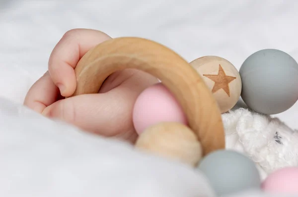 Ahşap bir oyuncakla oynamak bir bebek el kapatın. Odaklanmamış arka plan