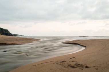 Cantabria deniz. Ön planda denize Nora Beach bir dere akar. Asturias, İspanya.