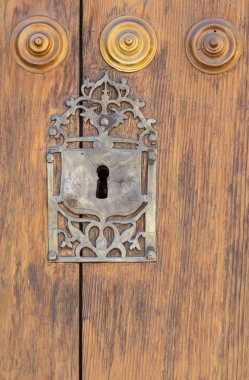 Eski panelli ahşap kapıda anahtar deliği; paslı ve yıpranmış