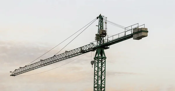 Silueta de la grúa de construcción de la torre y el edificio contra un hermoso cielo al atardecer —  Fotos de Stock