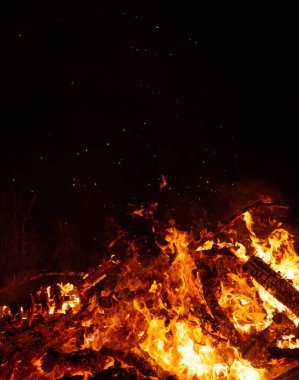 Ateş kıvılcımlarıyla yanan ağaçlar, alevler ve gece şöminesi..