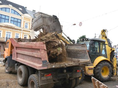Uzhhorod, Ukrayna - 27 Haziran 2018: kazmak için kullanılan tarak ağaç kütükleri ve kökleri Uzhhorod, Ukrayna. Kökleri bir damperli kamyon üzerinde olarak yüklenmemesi. Şehir meydanında Petefi yeniden yapılanma