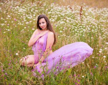 Pembe şal genç çıplak kadın sahada poz. Seksi sarışın zevk doğa ve yaz zaman açık havada