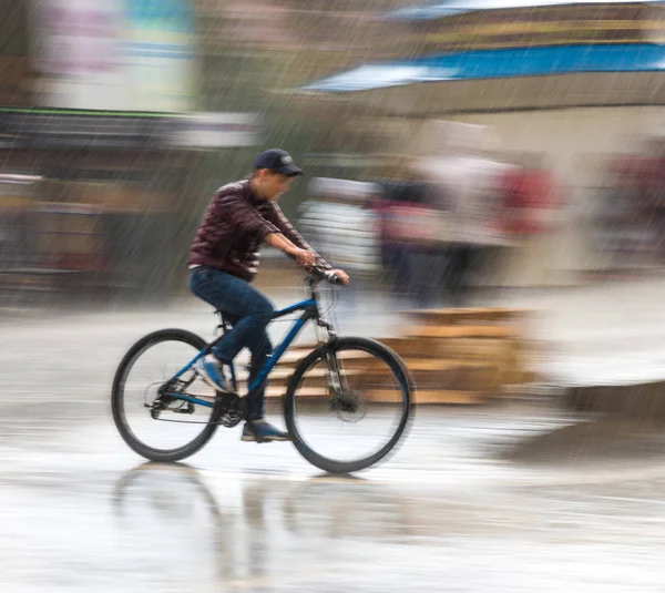 กรยานบนถนนในเม ในว ฝนตกในการเคล อนไหวเบลอ — ภาพถ่ายสต็อก