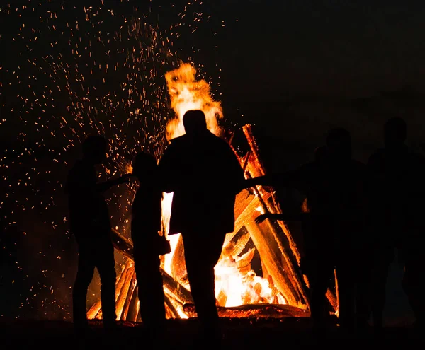 晚上在户外大篝火旁休息的人们 — 图库照片