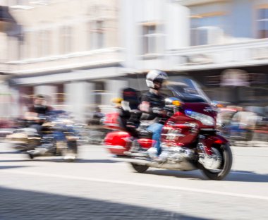 Motorcu güneşli gün motosiklet Binme. Kasıtlı hareket bulanıklığı. Ufuk yansıma