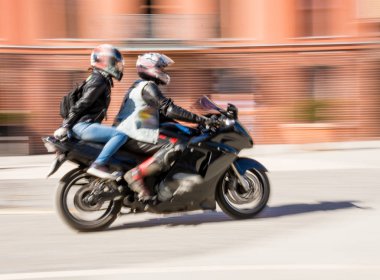 Bisikletçileri güneşli gün motosiklet Binme. Kasıtlı hareket bulanıklığı. Ufuk yansıma