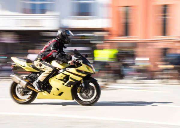 Biker riding motorcycle at sunny day. Intentional motion blur. Defocused image