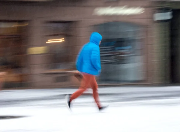 動きで雪に覆われた冬の日に通りを歩いて女性をぼかします イメージ — ストック写真