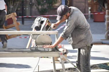 İşçi kesim granit fayans bir elmas elektrik inşaat sahasında testere