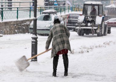 Şehir sokak kış kar kürekle kadın. Kasıtlı hareket bulanıklığı