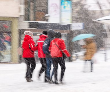 Şehir halkı kışın karlı bir günde cadde boyunca ilerliyorlar. Kasıtlı hareket bulanıklığı