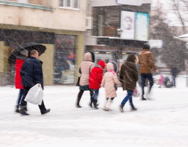 Şehir halkı kışın karlı bir günde cadde boyunca ilerliyorlar. Kasıtlı hareket bulanıklığı
