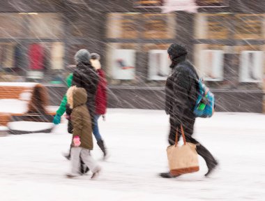 Şehir halkı kışın karlı bir günde cadde boyunca ilerliyorlar. Kasıtlı hareket bulanıklığı