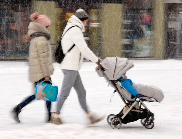 Familie Lopen Met Het Kind Wandelwagen Besneeuwde Winterdag Opzettelijke Bewegingsonscherpte — Stockfoto