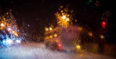 Yağmur damlaları sokak trafik ışıkları arka plan bulanık bir araba penceresindeki 