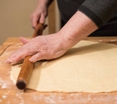 Klasik kruvasan evde üreten. Kadın daha fazla pişirme için hamur haddeleme