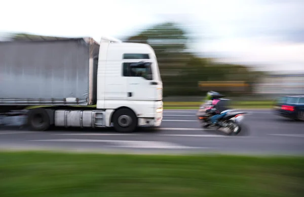 Peligrosa situación de tráfico urbano con un motociclista y un camión — Foto de Stock