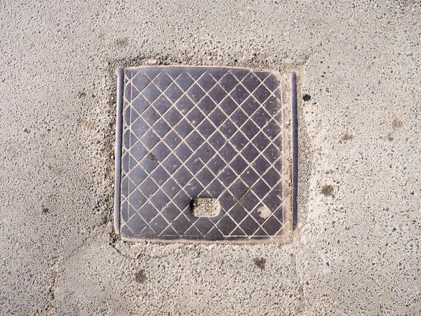 Канализационный металлический люк на тротуаре — стоковое фото