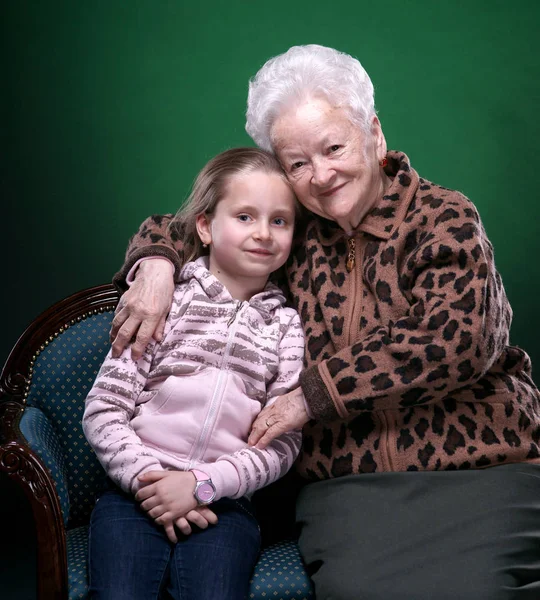 Счастливая улыбающаяся бабушка и внучка позируют в студии — стоковое фото