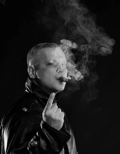 Retrato del hombre guapo con un cigarro en chaqueta de cuero — Foto de Stock