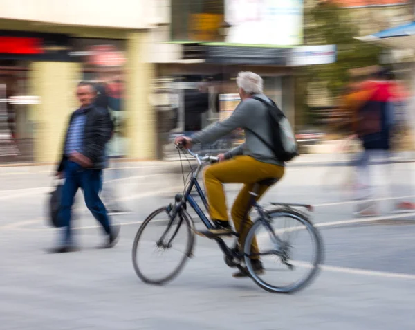 Ciclista en la carretera de la ciudad en desenfoque movimiento — Foto de Stock