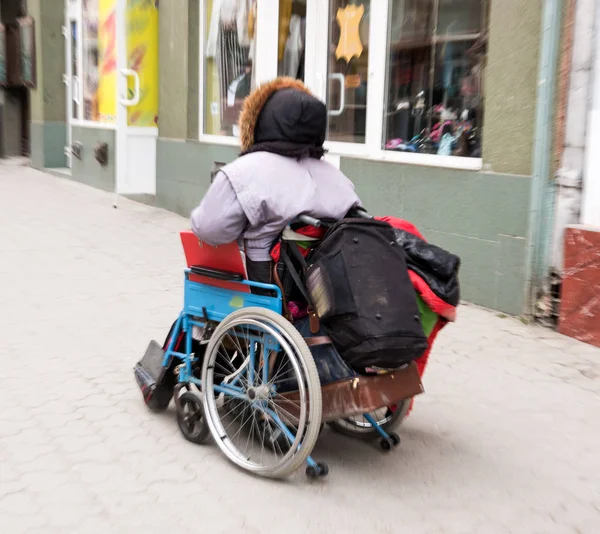 Una anciana en silla de ruedas en la calle de la ciudad. Intencional m —  Fotos de Stock