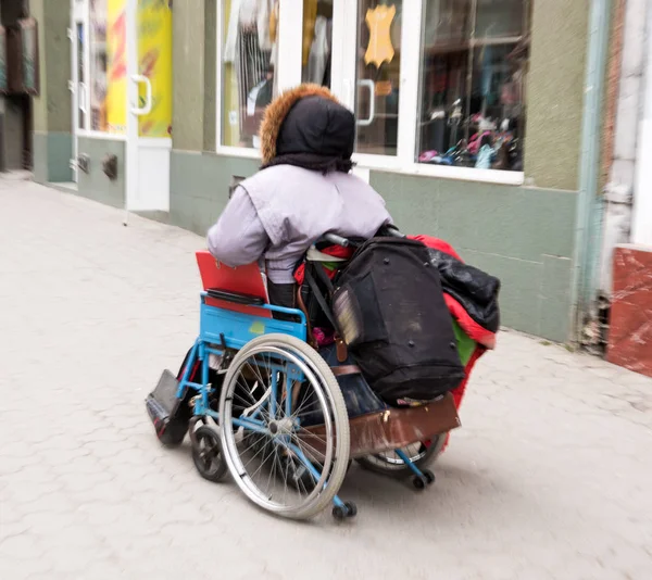 Vecchia in sedia a rotelle sul marciapiede della città. Intenzionale m — Foto Stock