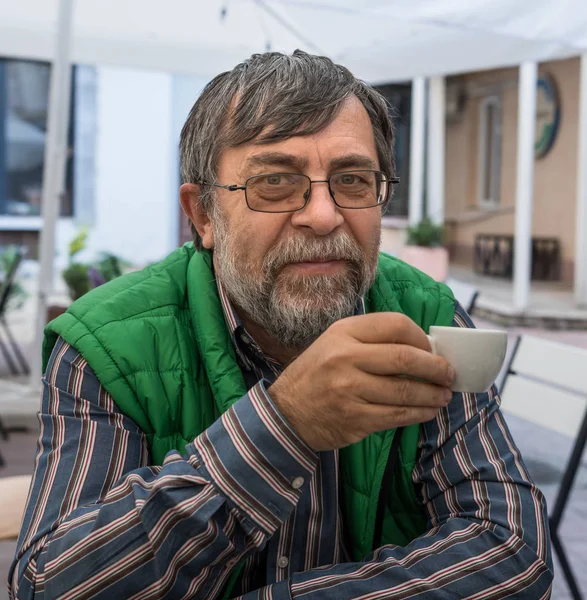 Porträt eines älteren Mannes, der auf der Terrasse Kaffee trinkt — Stockfoto