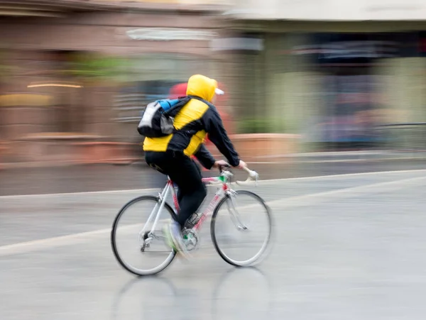 Cyklist på staden vägbanan i rörelse oskärpa — Stockfoto