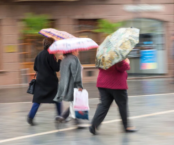 Pessoas com guarda-chuva andando pela rua no dia chuvoso — Fotografia de Stock