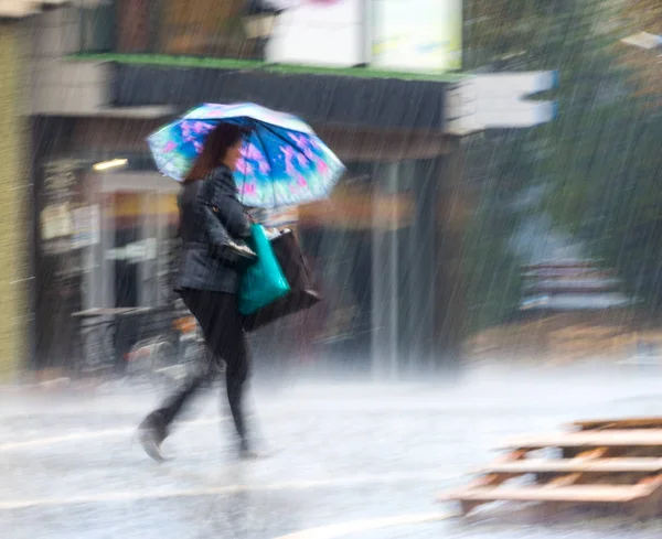 Les gens avec un parapluie marchant dans la rue le jour de pluie — Photo