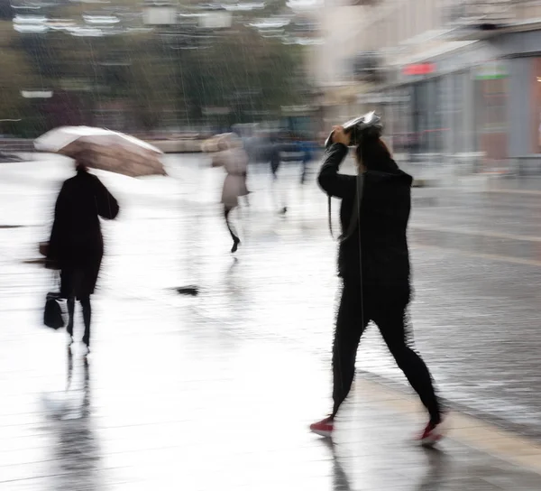 People with umbrella walking down the street on rainy day