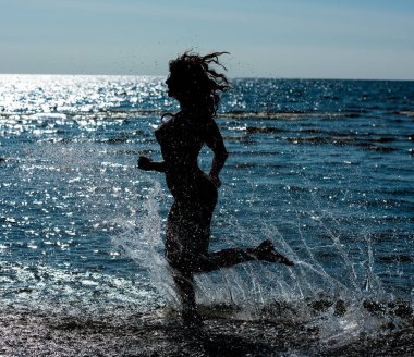 Denizde poz güzel çıplak genç kadın silüeti