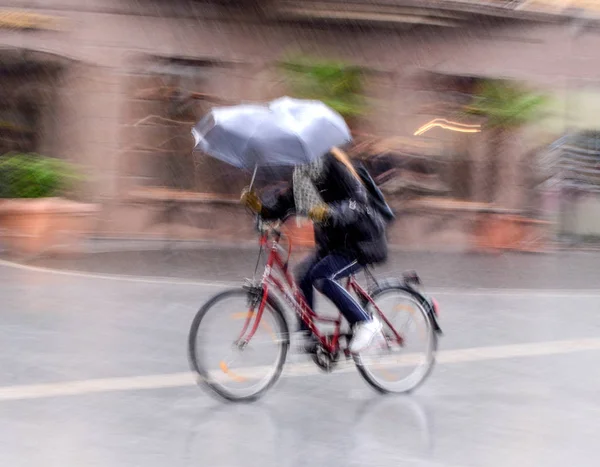 Cyclist on the city roadway in motion blur in rainy day — Stock Photo, Image