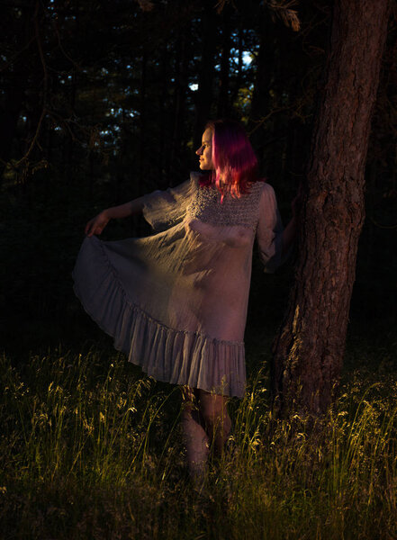 Beautiful young seminude woman in blue transparent dress enjoying summertime outdoors