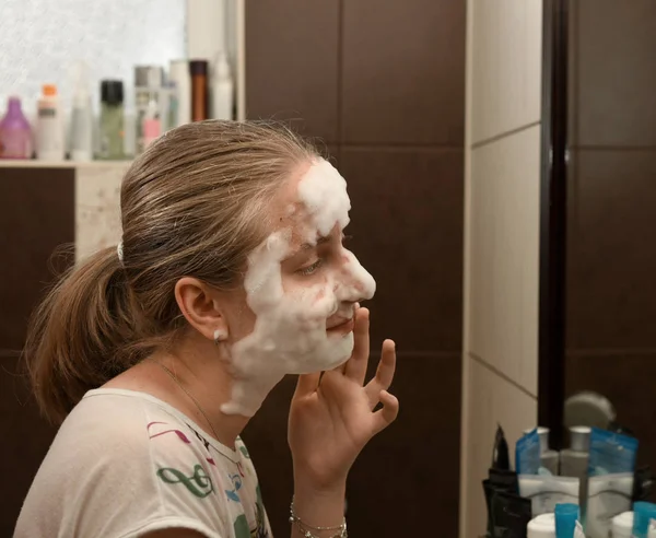 Chica adolescente aplicando una máscara de burbuja —  Fotos de Stock