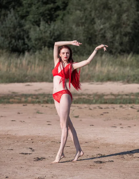 Beautiful redhead young woman in red transparent swimsuit — Stock Photo, Image