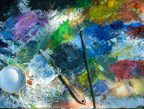 Artistic paintbrushes and palette knifes on old  palette — Stock Photo, Image