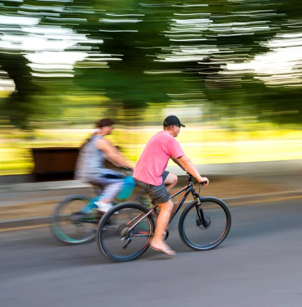 Due ciclisti sulla strada della città in movimento sfocano — Foto Stock