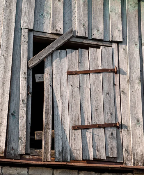 Trædør med lodrette planker og rustne jerndør hængsel - Stock-foto