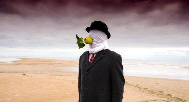 Kapalı kafası ve elma ile siyah bir takım elbise giymiş adam m