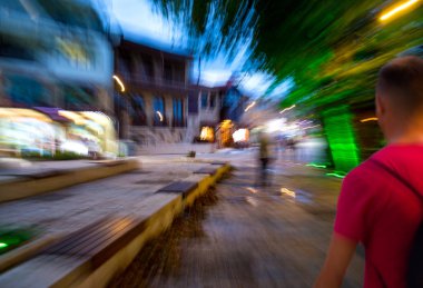 Akşamları cadde boyunca ilerleyen kalabalık şehirliler.