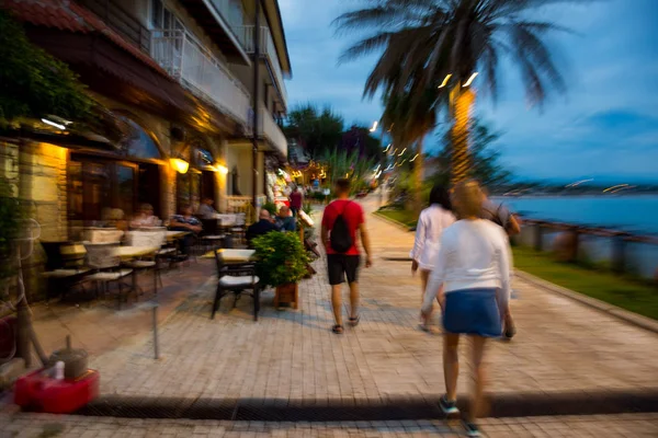 Gente ocupada de la ciudad que va a lo largo de la calle por la noche — Foto de Stock