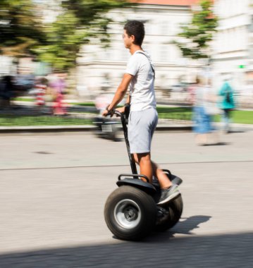 Elektrikli scooter kullanan bir adam açık havada hareket bulanıklığında